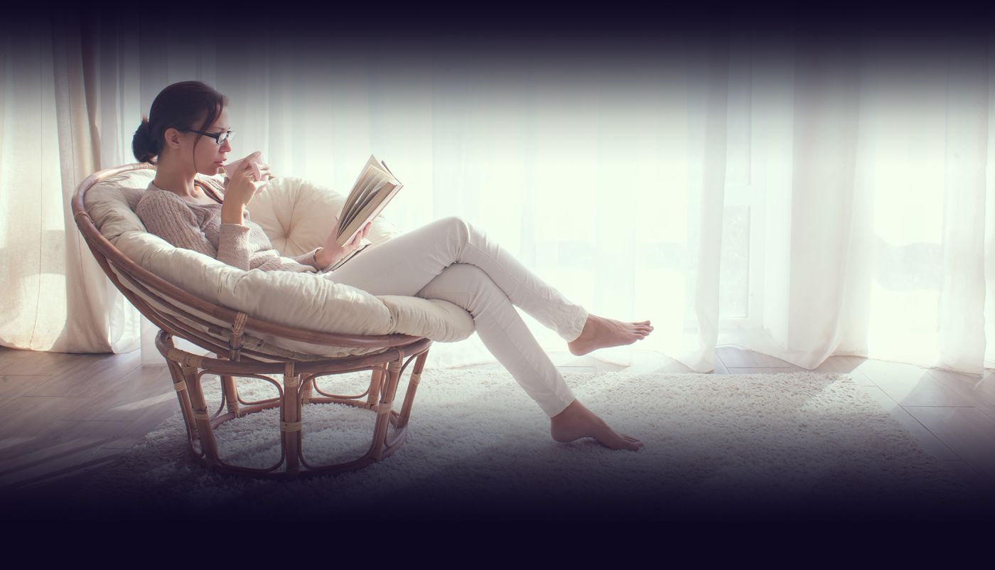 Vrouw leest ontspannen in een stoel bij daglicht